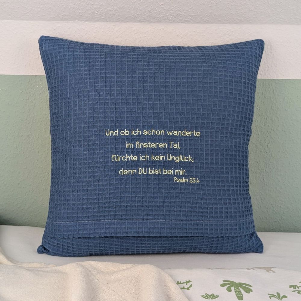 Quadratisches Kissen aus blauem Waffelstoff, bestickt mit Konfirmationsspruch.