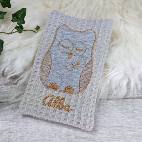 Stoffhülle aus Baumwolle für Kühlakku in creme, bestickt mit Eule und Name.