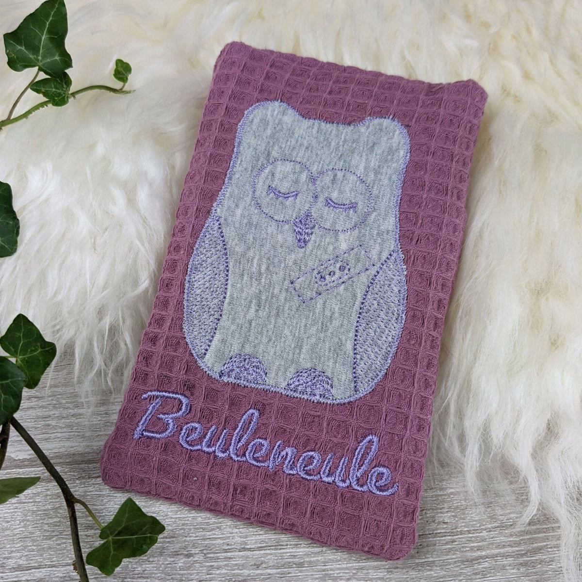Stoffhülle aus Baumwolle für Kühlakku in lavendel, bestickt mit Eule und Beuleneule.