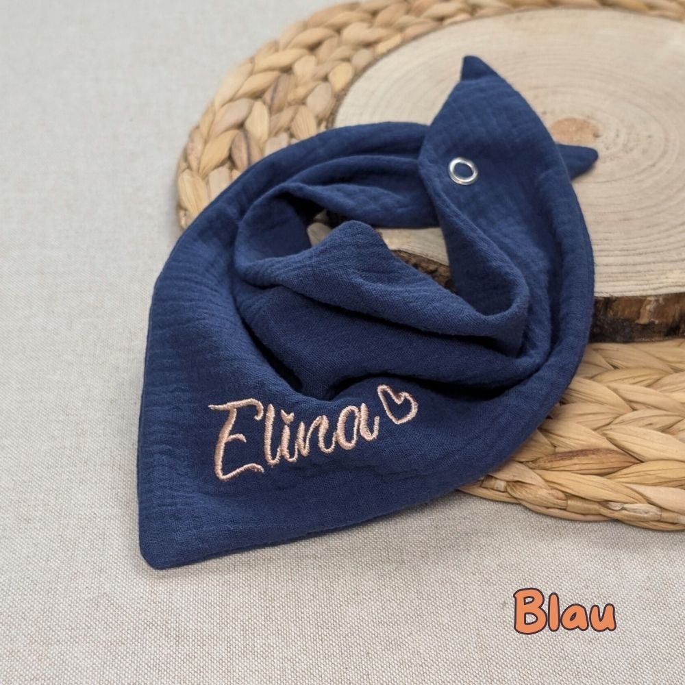 Es ist ein Halstuch aus Musselin bestickt mit dem Namen Elina und einem kleinen Herzen hinter dem Namen zu sehen. Das Tuch hat die Farbe blau.