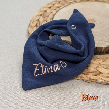 Es ist ein Halstuch aus Musselin bestickt mit dem Namen Elina und einem kleinen Herzen hinter dem Namen zu sehen. Das Tuch hat die Farbe blau.