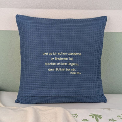 Quadratisches Kissen aus blauem Waffelstoff, bestickt mit Konfirmationsspruch. 