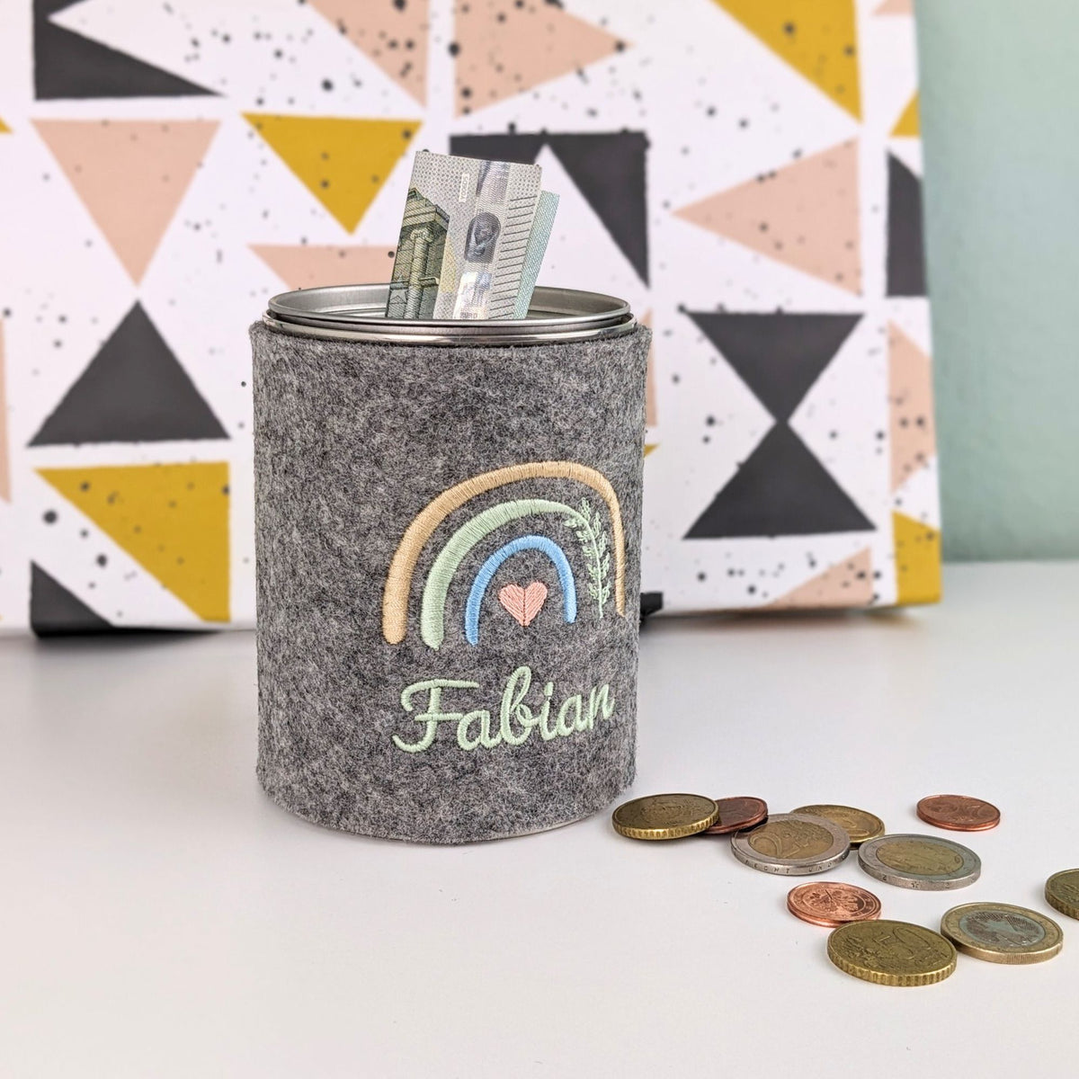 Metallspardose mit Filzmantel, bestickt mit Name und Regenbogen